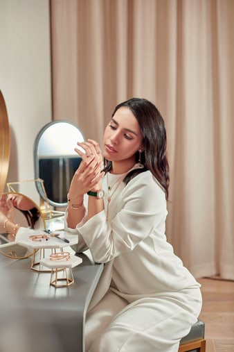 A woman wearing luxury rings with a rose gold diamond watch
