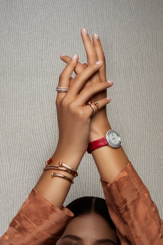 A woman pairing a rose gold wrap bangle bracelet with a white gold diamond watch