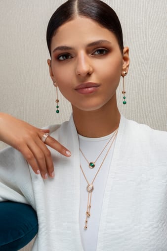 A woman combining rose gold diamond pendants with a diamond ring