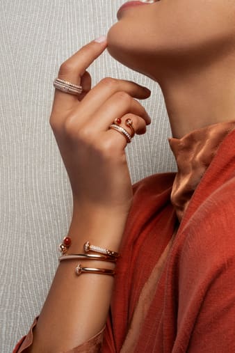 A woman wearing a diamond bangle bracelet set with carnelian and a rose gold open ring