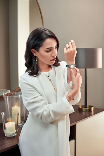 A woman looking at the bracelet of her luxury watch